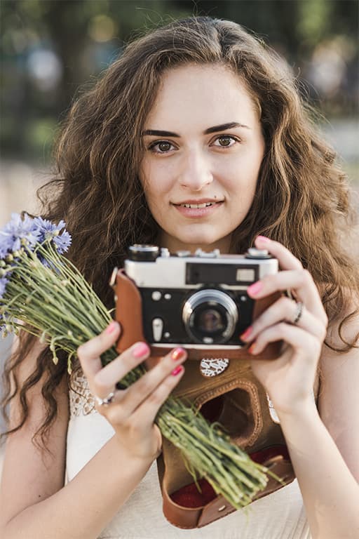 femme avec une camera photo et des fleurs