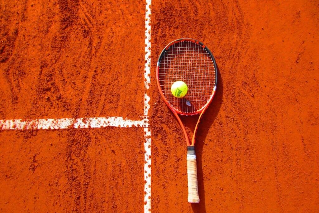 photographie sportive balle et raquette de tennis posé sur le terrain de-tennis